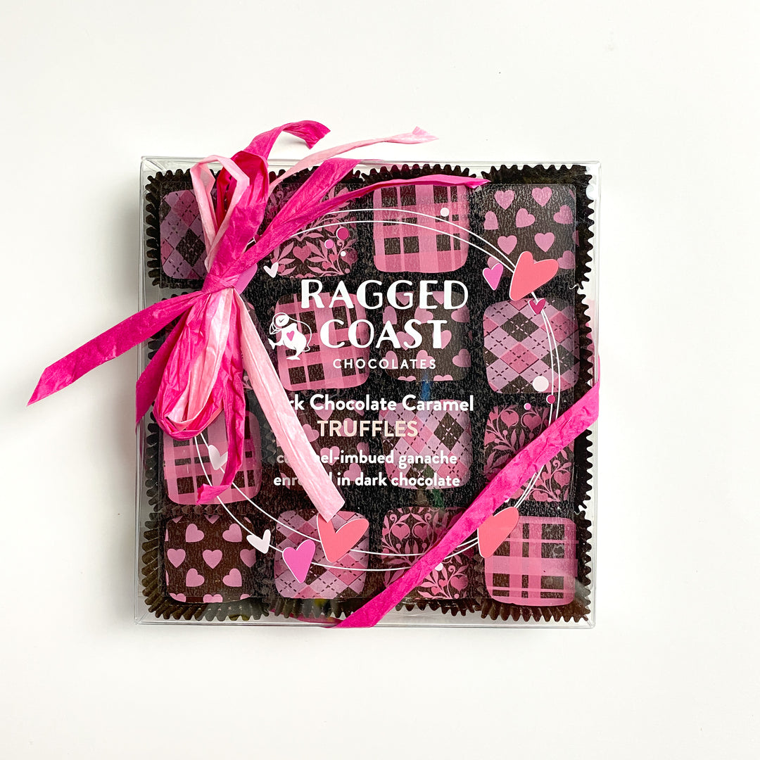 A box of Ragged Coast Chocolates Dark Chocolate Caramel Truffles, featuring heart-themed packaging and a pink ribbon, crafted with rich bittersweet chocolate from Ecuador.