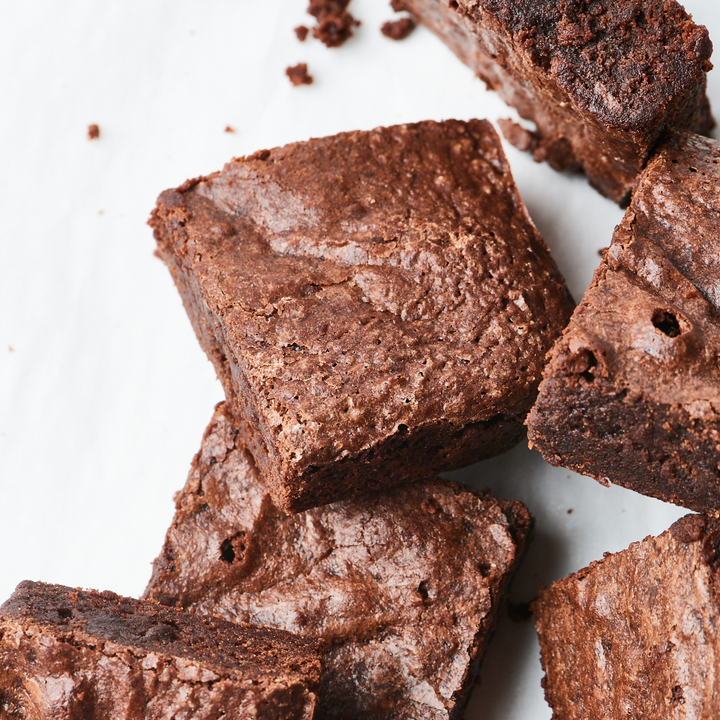 Close-up of freshly baked Craft Chocolate Brownies made from organic sugar and direct-trade cocoa from Ragged Coast Chocolates on a white surface.