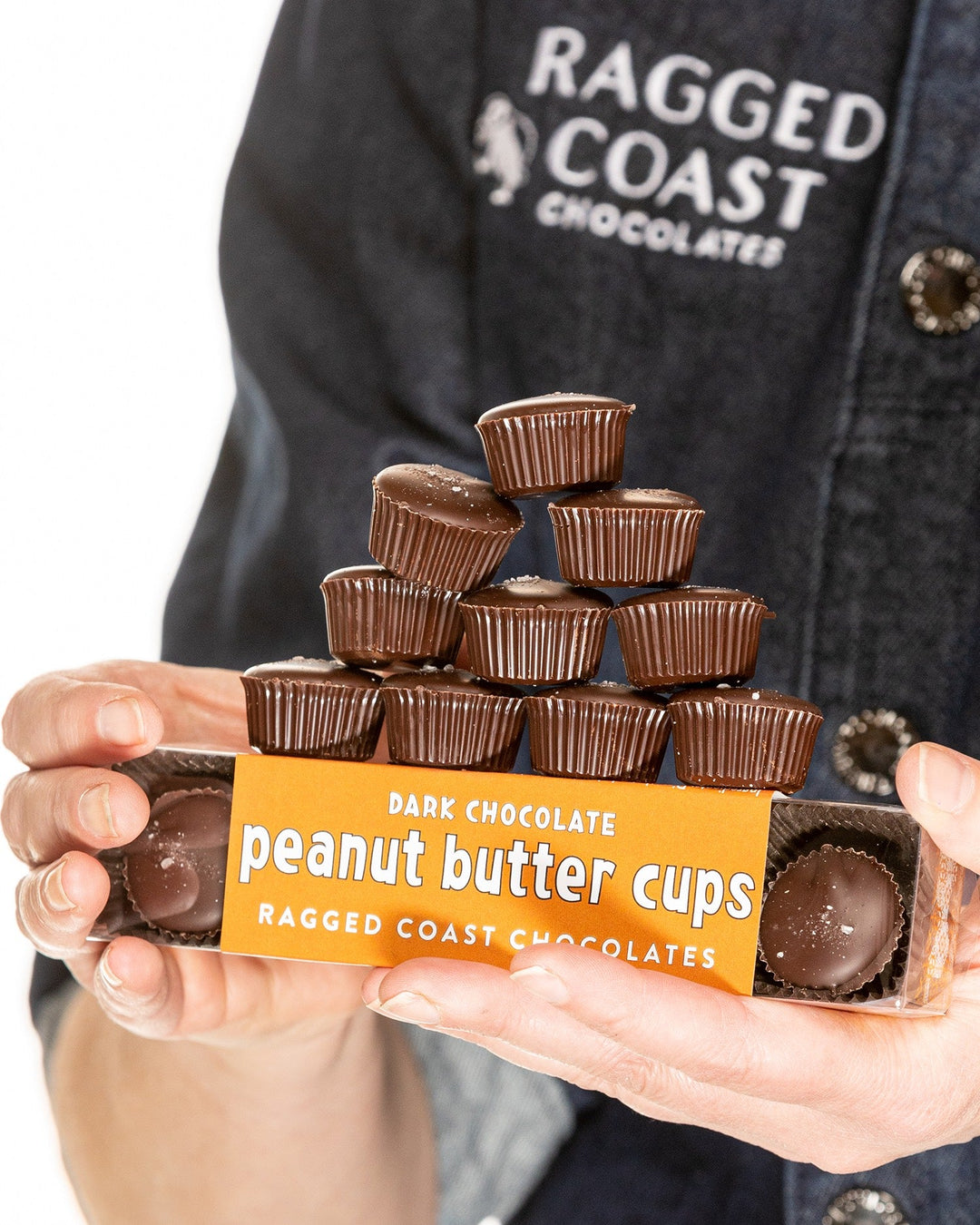Person holding a box of Ragged Coast Chocolates Dark Chocolate Peanut Butter Cups.
