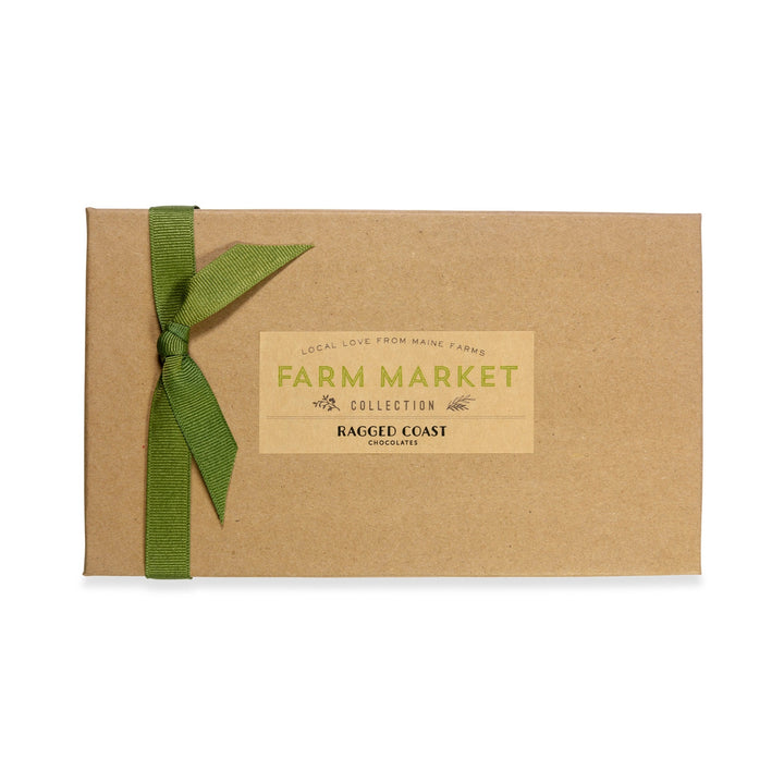 A Maine Farm Market Truffle Collection gift box with a green ribbon and a "Maine local ingredients" label tied on the front against a white background. (Brand Name: Ragged Coast Chocolates)