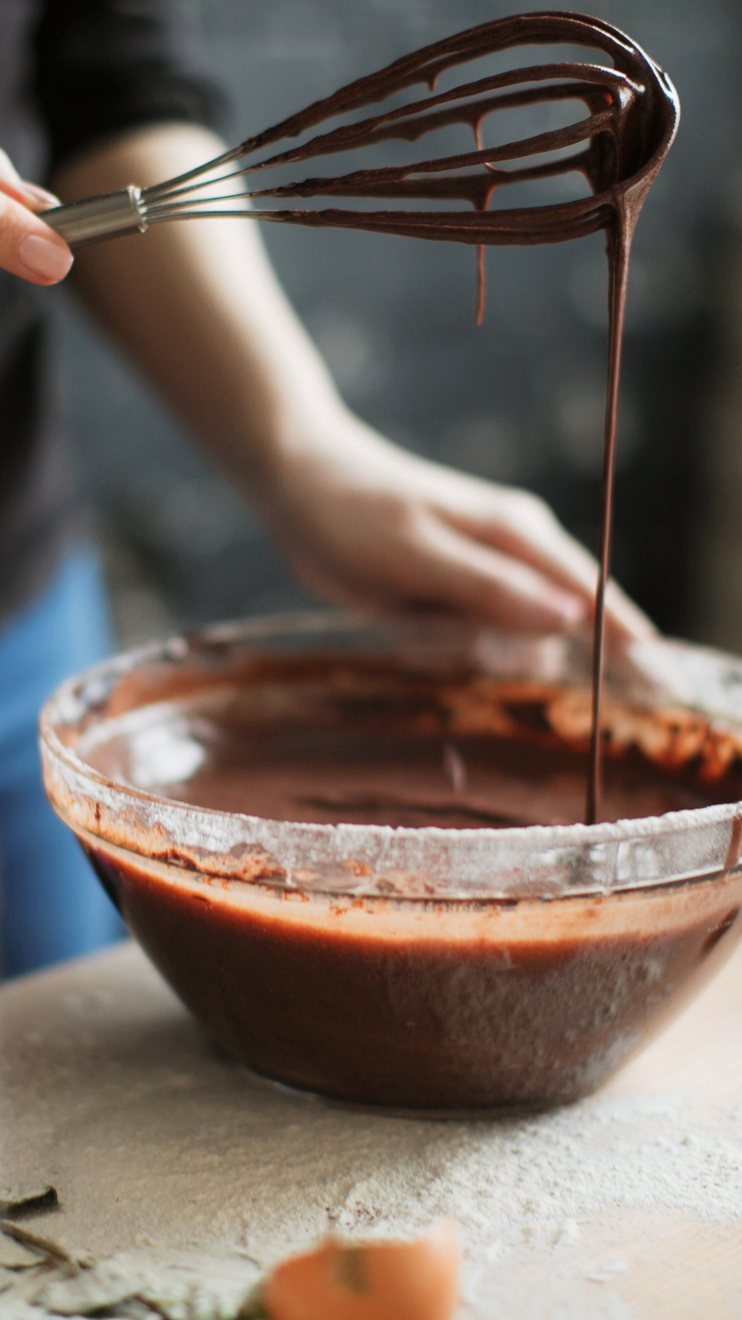 Person whisking melted chocolate in a bowl.