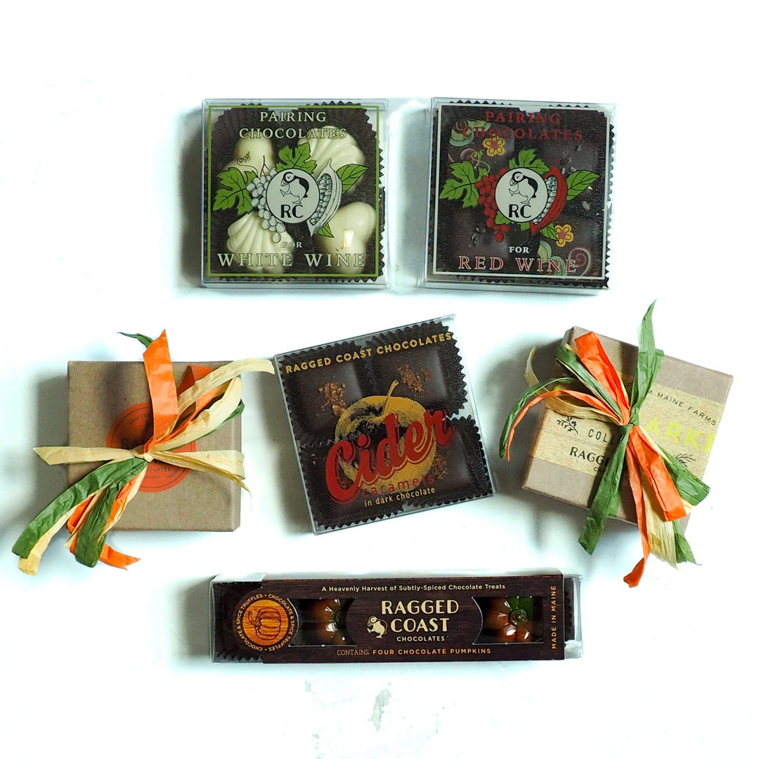 Five Autumn Chocolate Sampler Gift Boxes, including two wine pairing sets, two wrapped in raffia ribbon, and one containing four pumpkin-shaped chocolates.