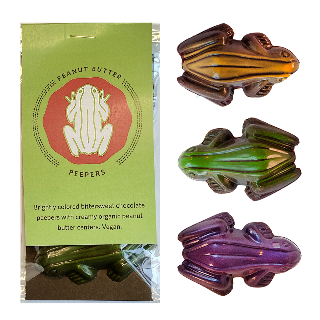 Chocolate candies shaped like frogs with peanut butter filling, labeled as vegan are the Peanut Butter Peepers made by raggedcoastchocolates.