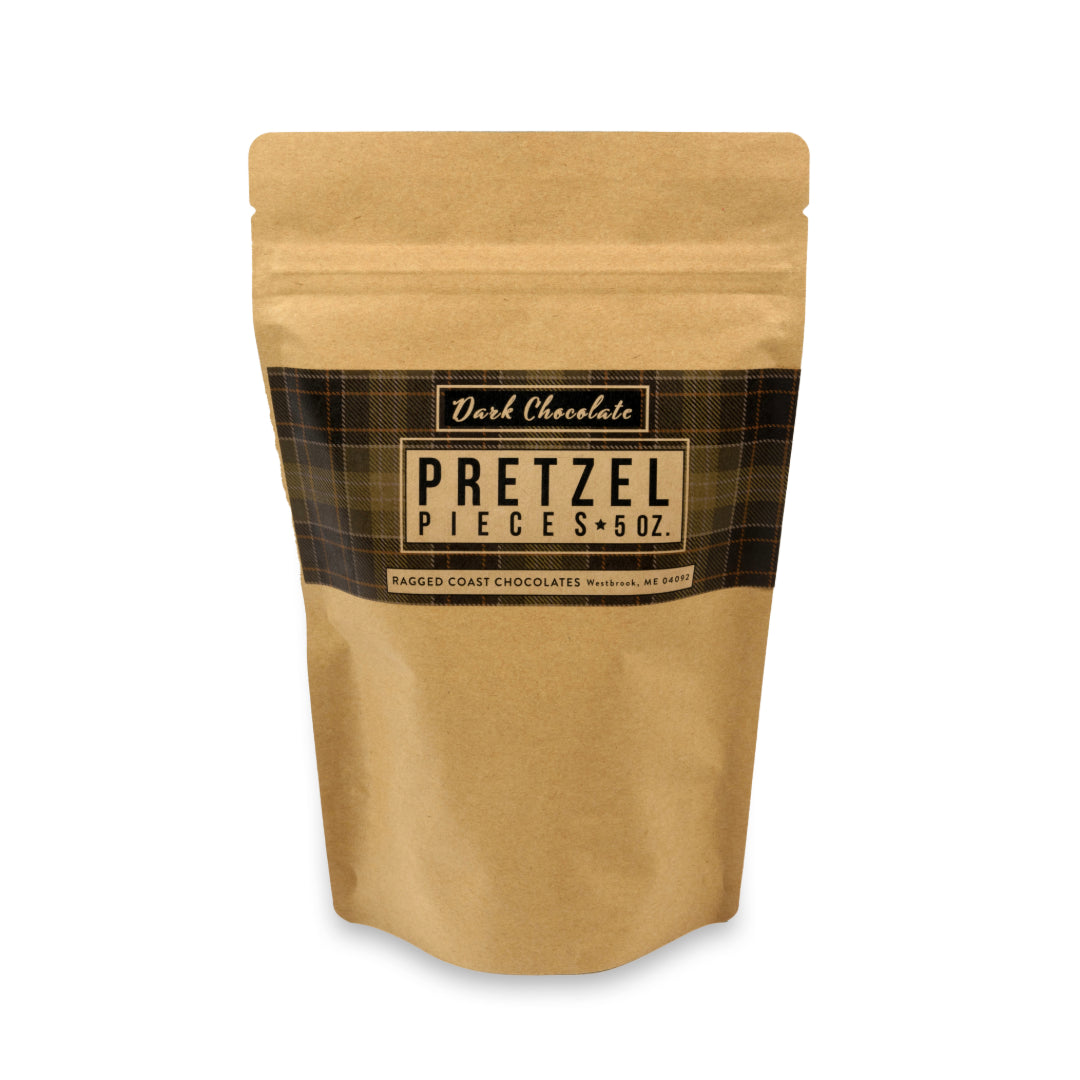 Packaged dark chocolate-covered pretzel pieces in a brown paper pouch with a Ragged Coast Chocolates label.