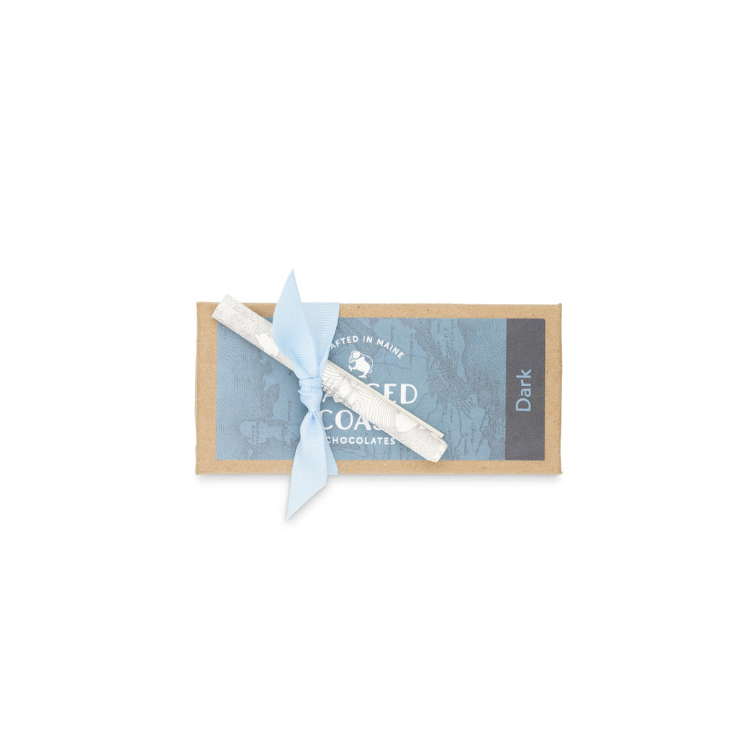 A box of Ragged Coast Chocolates dark chocolate truffle assortment tied with a light blue bow on a white background.