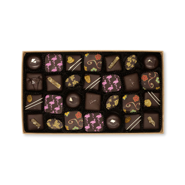 A box of Ragged Coast Chocolates' Dark Chocolate Truffle Assortment, including dark chocolate truffles and dark chocolate sea salt caramels, with various toppings and decorations.