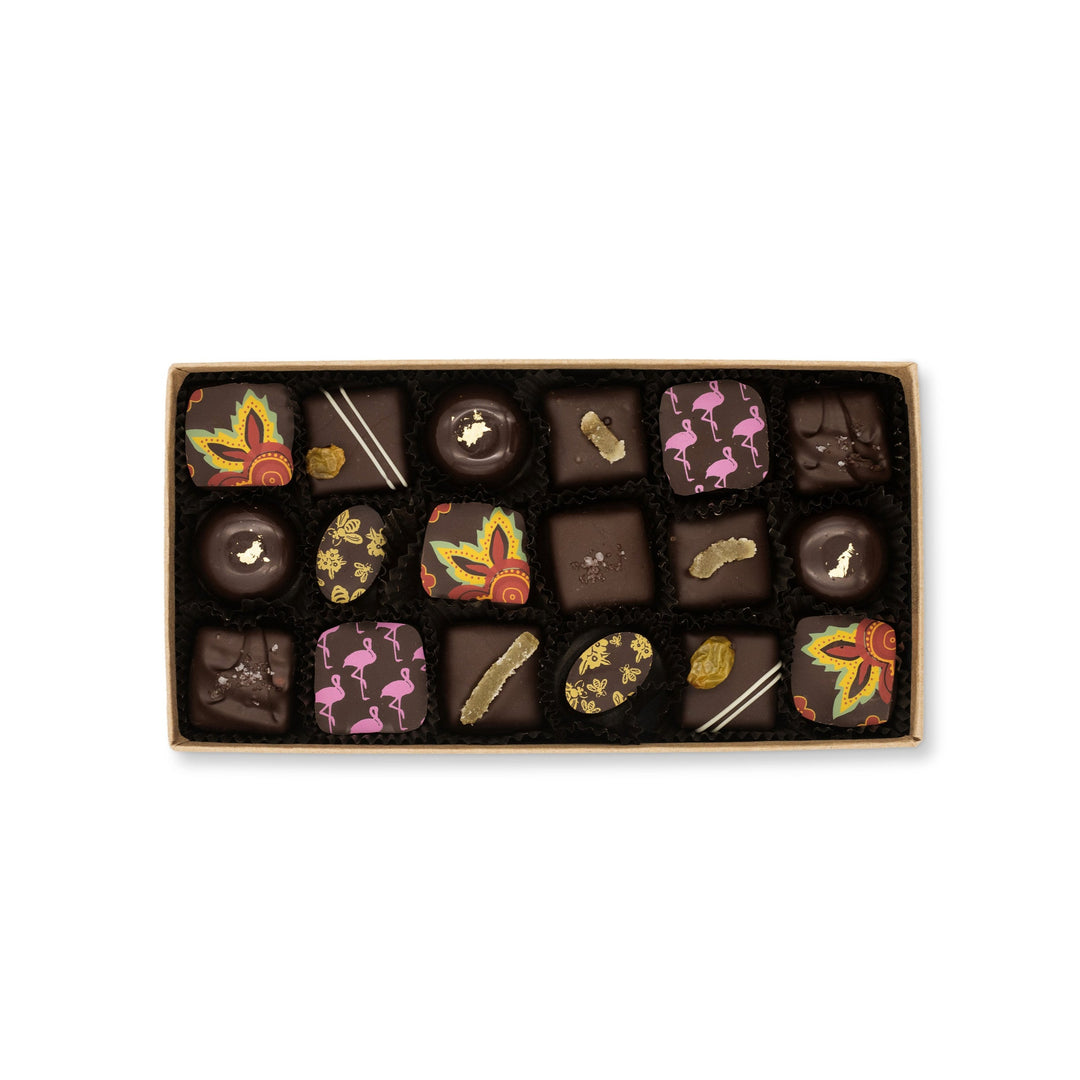 A box of Ragged Coast Chocolates' assorted Dark Chocolate Truffle Assortment with various decorations on a white background.