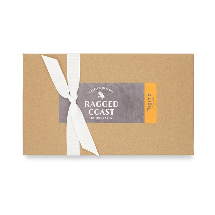 Brown paper packaging for Ragged Coast Chocolates Flagship Sea Salt Caramels with a white ribbon and a branding label.