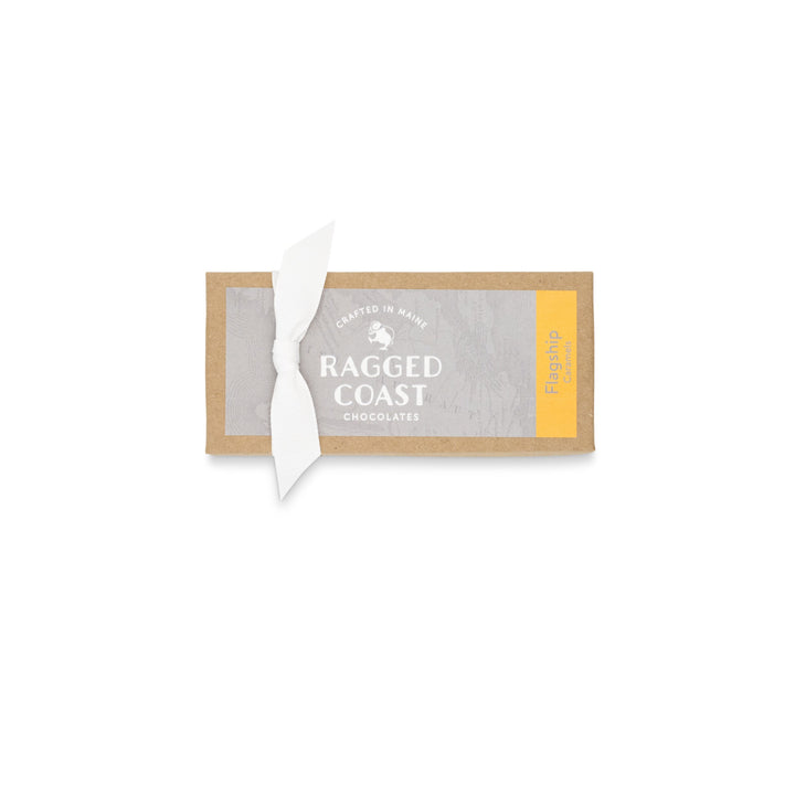 Chocolate bar packaging with torn paper revealing the brand "Ragged Coast Chocolates," featuring direct-trade Ecuadorian dark chocolate.