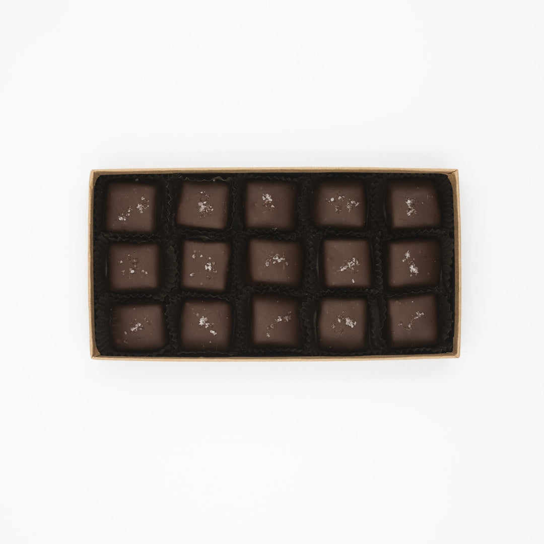 A box of identical square Ragged Coast Chocolates Flagship Sea Salt Caramels arranged neatly in rows.