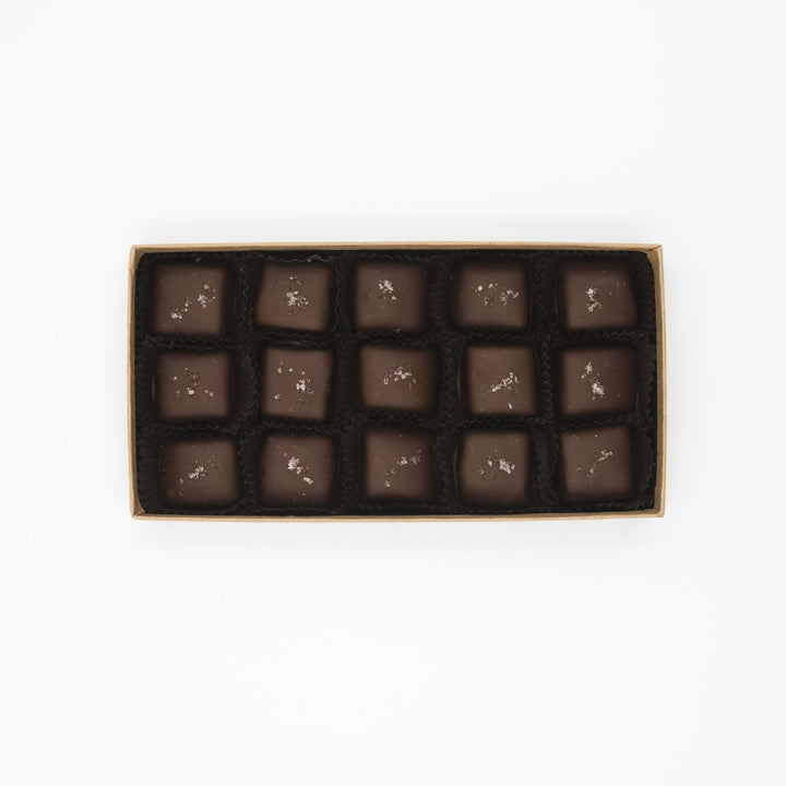 A box of identical square Ragged Coast Chocolates Flagship Sea Salt Caramels arranged neatly in rows.