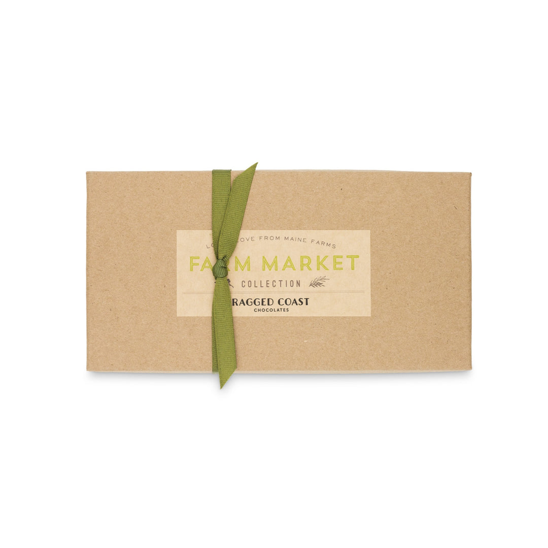 Ragged Coast Chocolates Maine Farm Market Truffle Collection Kraft paper gift box with a green ribbon and a vintage-style "farm market collection" label, isolated on a white background.