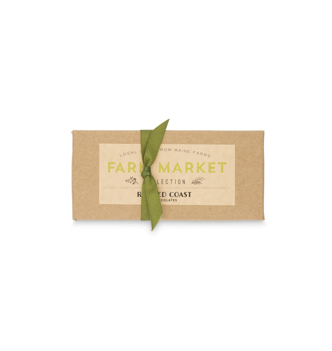 A bar of Ragged Coast Chocolates Maine Farm Market Truffle Collection with a green leaf on its brown paper packaging, displayed on a plain white background.