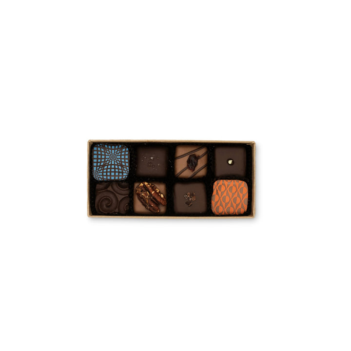 Assortment of gourmet chocolates, including dark chocolate sea salt caramels and Maine Farm Market Truffle Collection, in a box by Ragged Coast Chocolates.