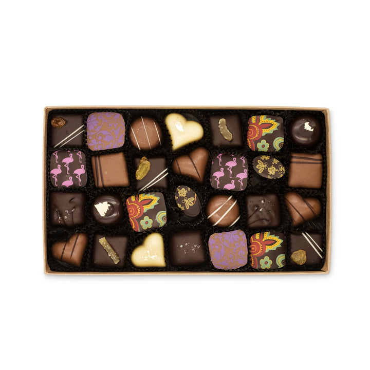 An assortment of Grand Assortment of Milk and Dark Chocolate Truffles in various shapes and designs, including dark chocolate truffles, neatly arranged in a box from Ragged Coast Chocolates.