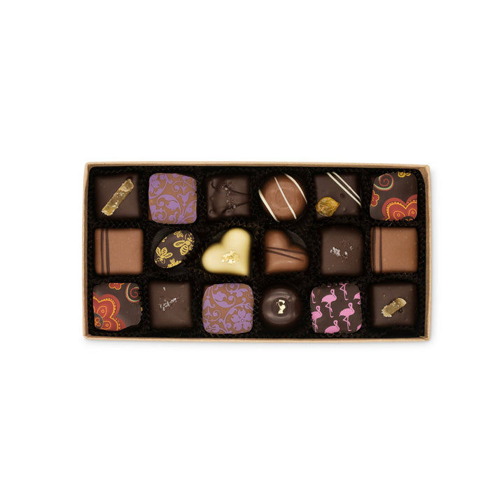An assortment of Grand Assortment of Milk and Dark Chocolate Truffles, including dark chocolate sea salt caramels and milk chocolate truffles, displayed in a box from Ragged Coast Chocolates.