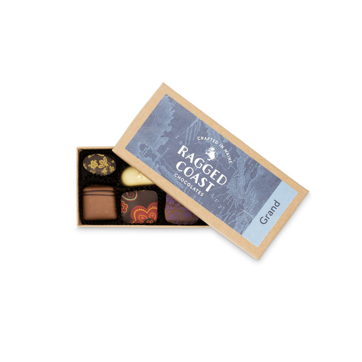 Open box of Grand Assortment of Milk and Dark Chocolate Truffles from Ragged Coast Chocolates, with a "crafted on the ragged coast" label.