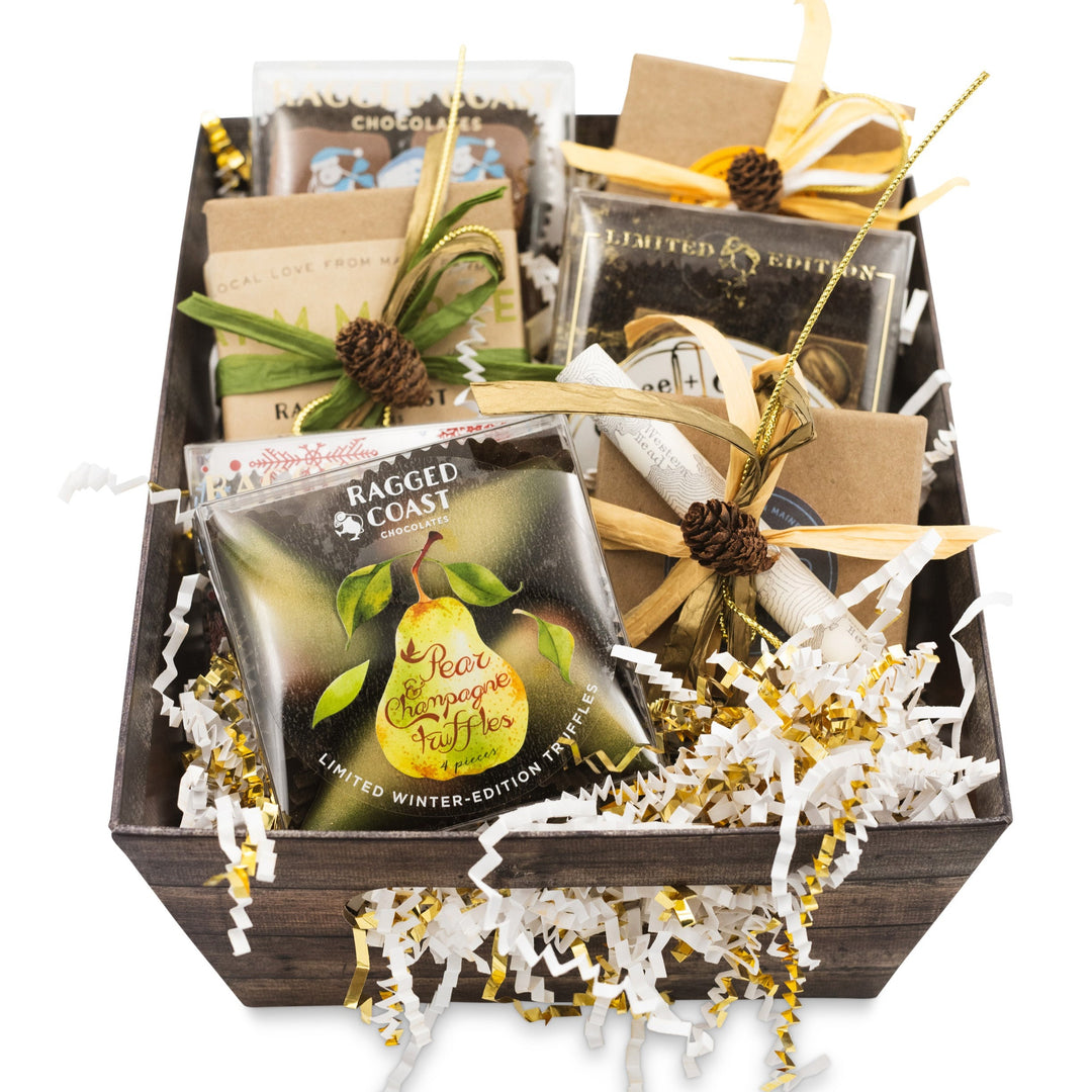 An open gift box containing an assortment of items including chocolates and decorative objects.