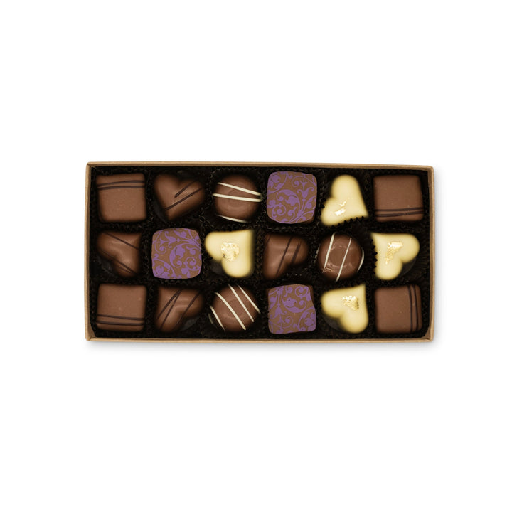 Assorted chocolates in a box, including Ragged Coast Chocolates' Milk Chocolate Truffle Assortment, dark, and white varieties with decorative patterns, packaged in recyclable paperboard boxes.
