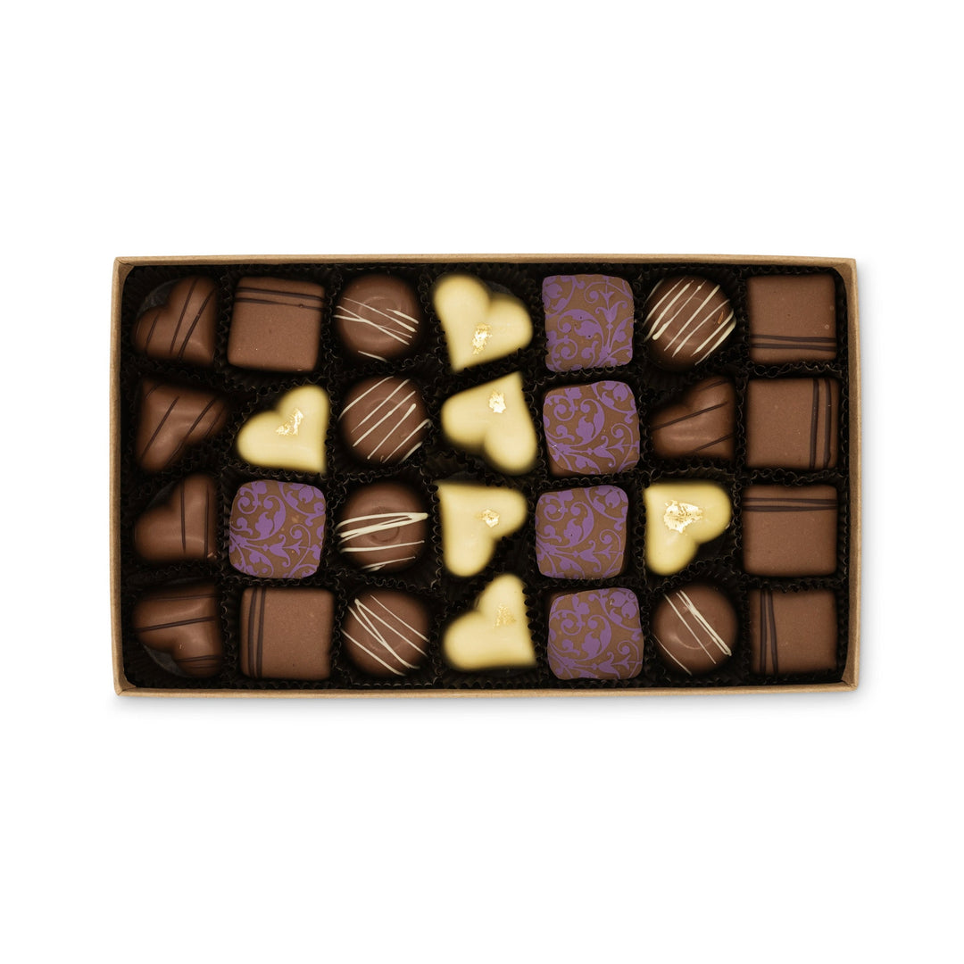 A box of Ragged Coast Chocolates Milk Chocolate Truffle Assortment in various shapes and designs.
