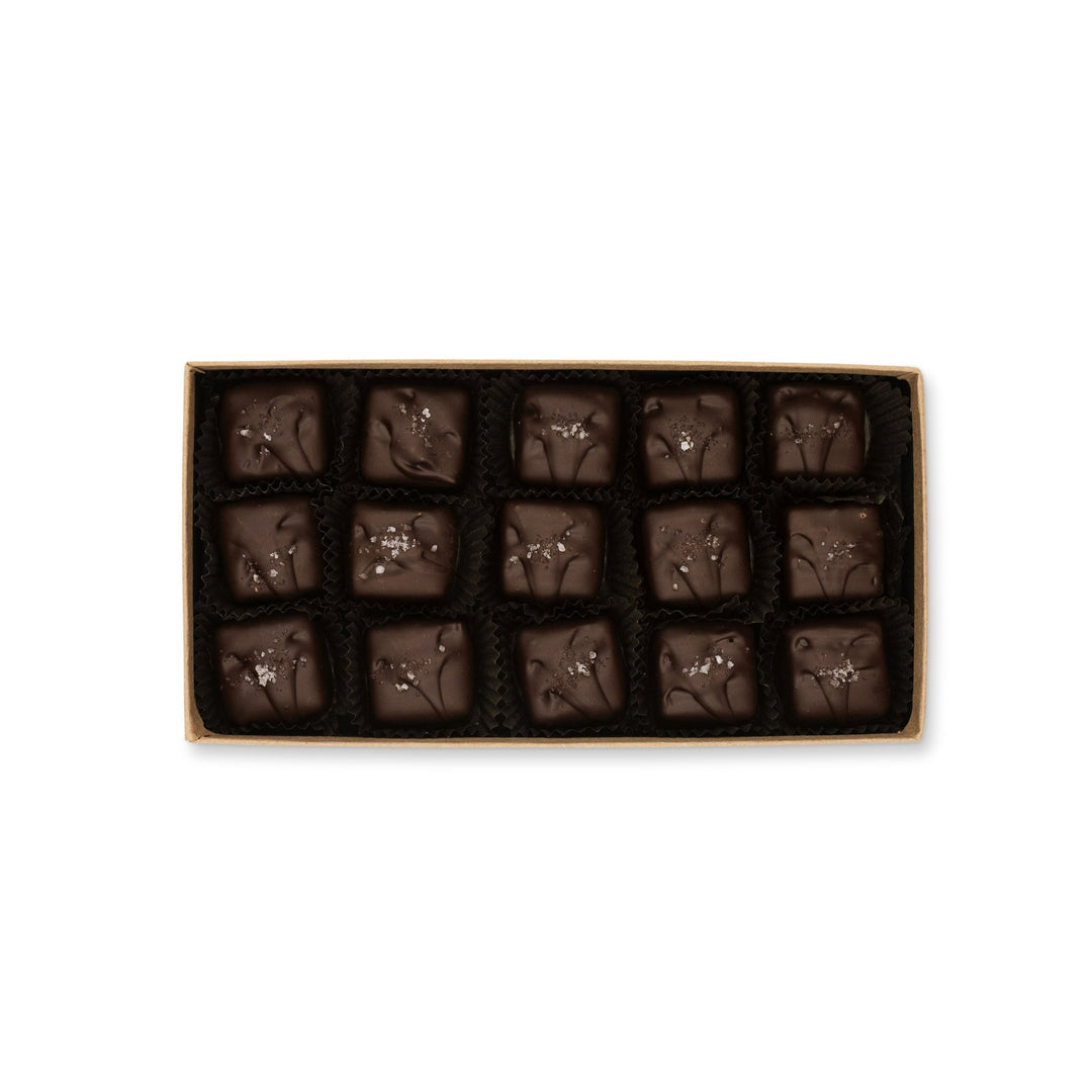 A box of identical Sea Turtle Caramels by Ragged Coast Chocolates arranged in neat rows on a white background.