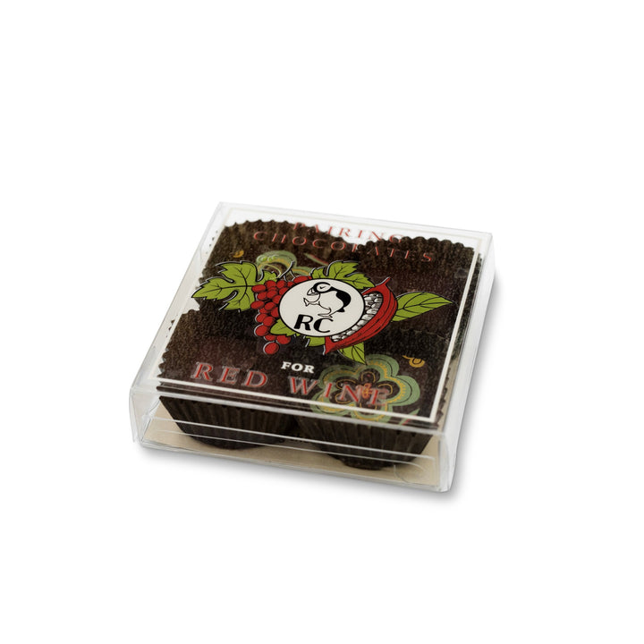 A pack of matches in a transparent case with a vintage "red crown" design on the cover, ideal for candle-lit evenings featuring Ragged Coast Chocolates for Wine Pairing.