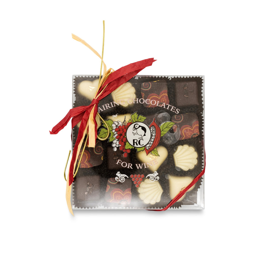 A box of Ragged Coast Chocolates for Wine Pairing tied with a red and gold ribbon.
