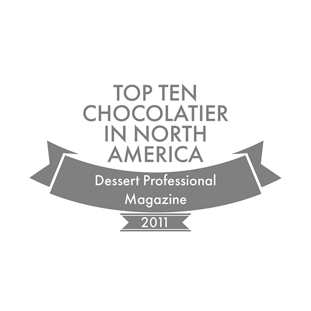 Graphic emblem indicating an award for being one of the "top ten chocolatier in north america" by dessert professional magazine in 2011.
