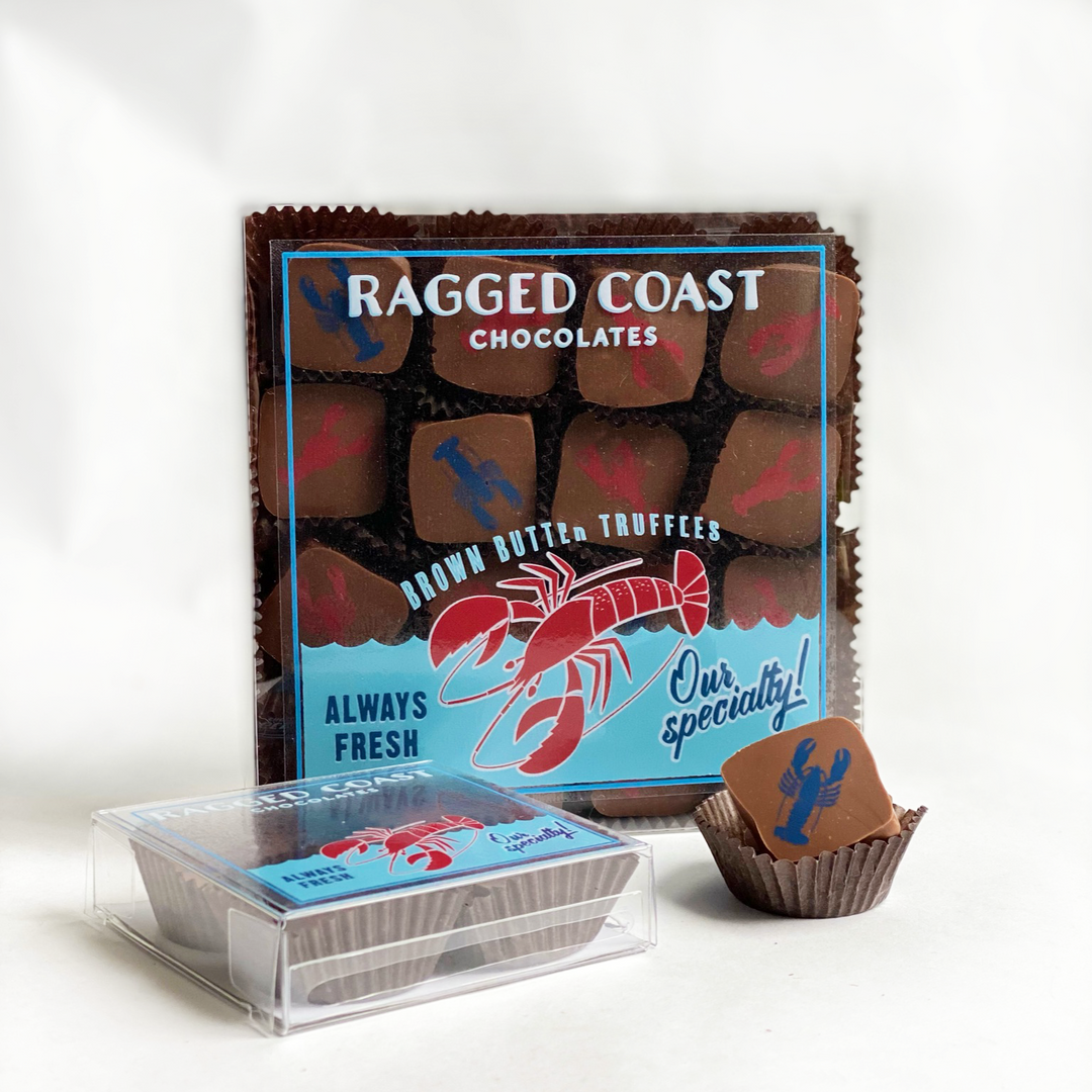 A box of ragged coast chocolates acorn butter truffles with an open package showing a single truffle in front.