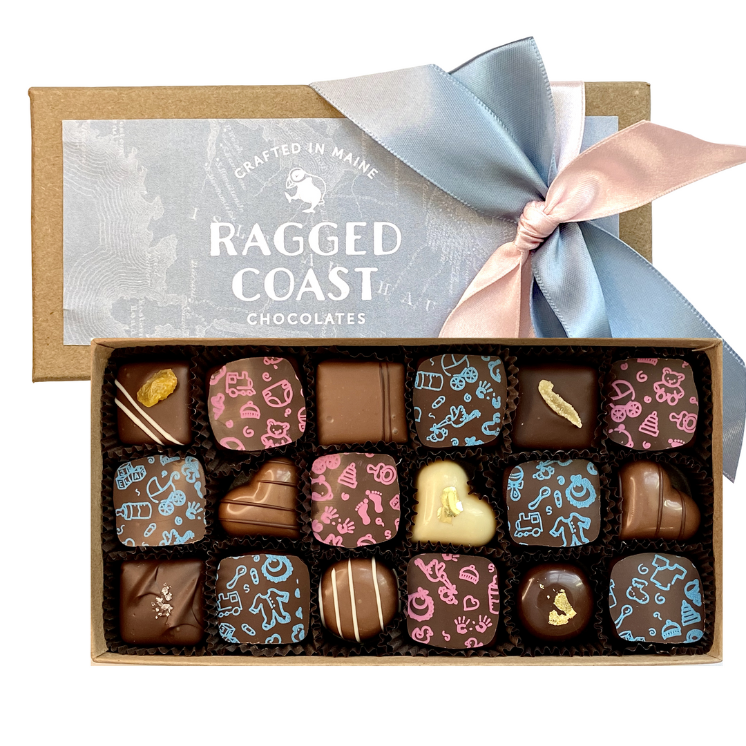 A box of assorted, decorative chocolates tied with a light blue ribbon from Ragged Coast Chocolates, perfect as Baby Shower or New Parent Chocolate Chocolate Gift favors.