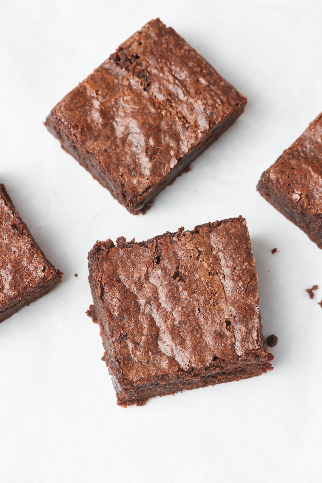 Freshly baked brownies, made from Ragged Coast Chocolates Baking Mix Gift Box, arranged on a white surface.