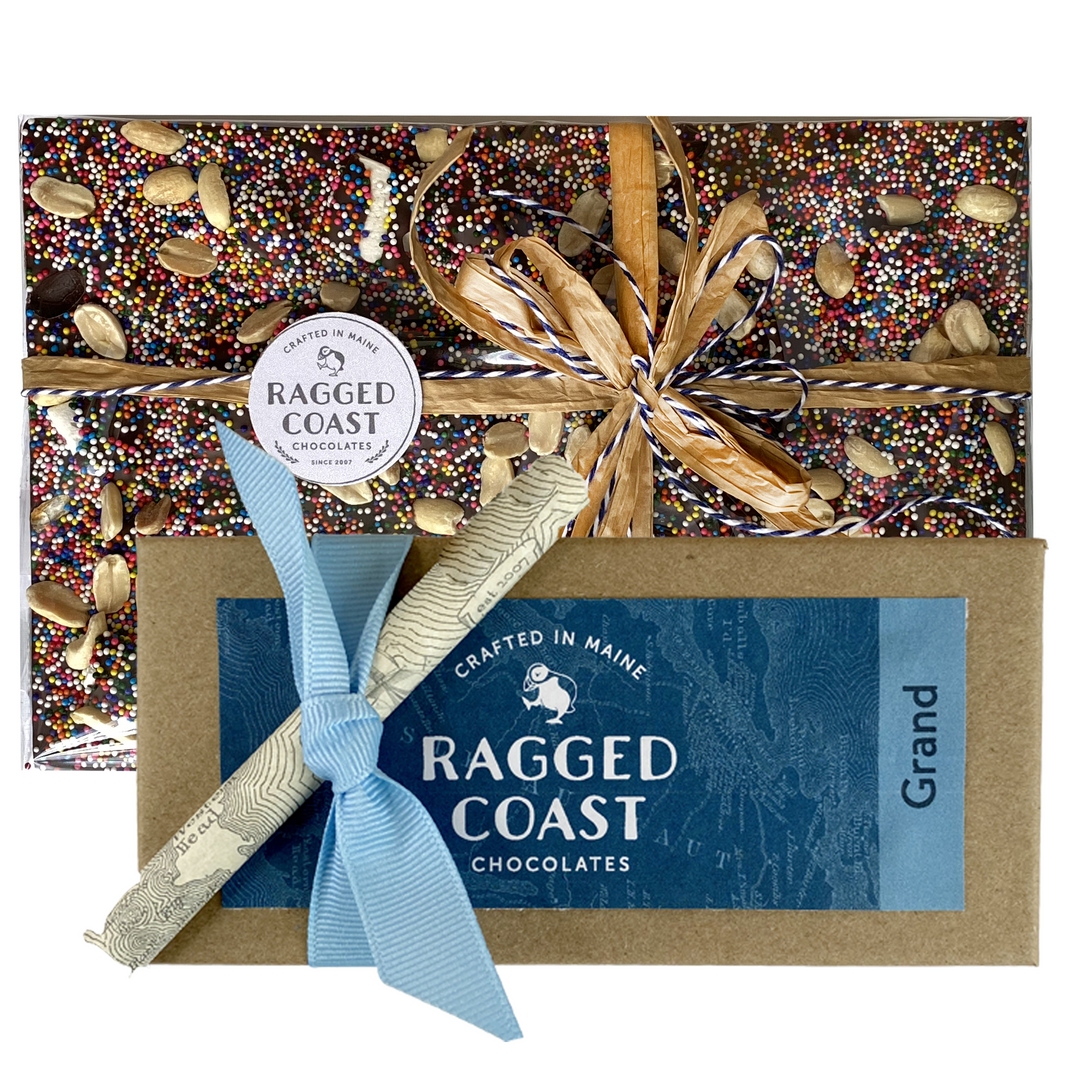 A gift-wrapped box of The Ridiculous and the Sublime Chocolate Gift Set from Ragged Coast Chocolates with a decorative bow.