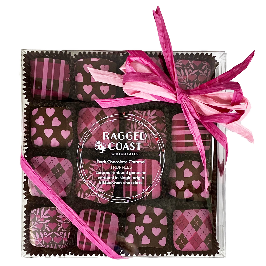 A gift box of Ragged Coast Chocolates, including Dark Chocolate Caramel Truffles made with single-origin Ecuadorian bittersweet chocolate, with pink and brown patterned wrappers, tied with a pink ribbon.